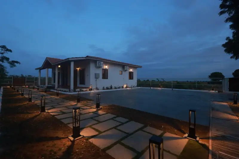 Farm cottage at GreenX lit up at dusk